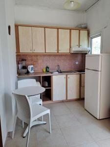 małą kuchnię ze stołem i białą lodówką w obiekcie Evridiki Apartments w mieście Mesongi