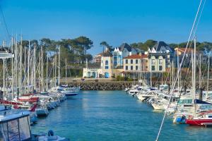 eine Gruppe von Booten, die in einem Yachthafen mit Häusern angedockt sind in der Unterkunft Villa neuve tout confort SHABBY CHIC in Talmont