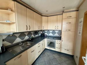 a kitchen with wooden cabinets and a sink at Monteurs- und Ferienwohnung Kahmen in Ahaus
