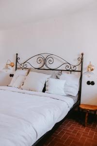 a bedroom with a bed with white sheets and pillows at Unique historical home, middle of the village, bath & patio in Tourtour