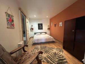 a bedroom with a bed and a couch at Le Panier Fleuri in Lacanau