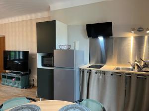 eine Küche mit Edelstahlgeräten und einem Fernseher in der Unterkunft Bord de l'eau, grand appartement in Saint-Pryvé-Saint-Mesmin + 7 Fotos