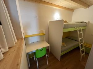 a small room with a bunk bed and a desk at Mountain Chalet Splazoi in Strembo