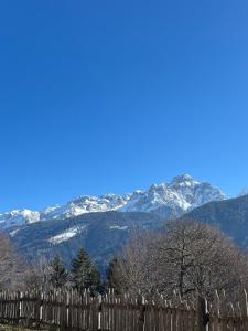 a fence with snow covered mountains in the background at Mountain Chalet Splazoi in Strembo
