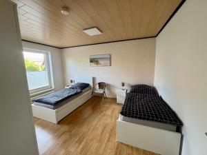 a bedroom with two beds and a window at Monteurs- und Ferienwohnung Kahmen in Ahaus