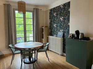 a kitchen with a table and chairs in a room at Bord de l'eau, Vues incroyables in Saint-Pryvé-Saint-Mesmin