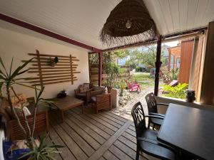 a screened in porch with a table and chairs at Le Panier Fleuri in Lacanau