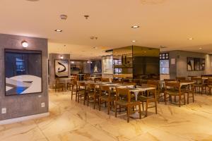 a restaurant with tables and chairs in a room at OZPED Flats Particulares Edifício Brasília Lets Ideia in Brasilia
