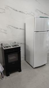 a kitchen with a stove and a refrigerator at Apartamento 4 completo centro in Sorriso