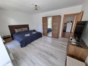 a bedroom with a bed and a tv in it at Levendula Apartman Bükkszentkereszt in Bükkszentkereszt