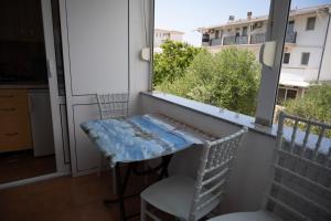 东吉托伊apartmani DENI的小阳台,配有桌子和窗户