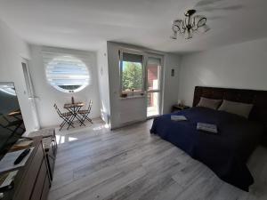 a bedroom with a bed and a table and a window at Levendula Apartman Bükkszentkereszt in Bükkszentkereszt