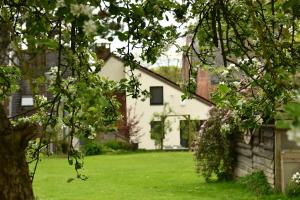 a white house with a yard with green grass at Au four et au jardin in Namur
