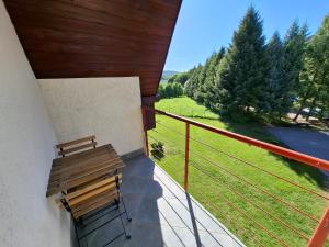 a bench on a balcony with a view of a field at Levendula Apartman Bükkszentkereszt in Bükkszentkereszt
