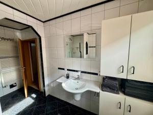 a bathroom with a sink and a mirror at Monteurs- und Ferienwohnung Kahmen in Ahaus +20 photos
