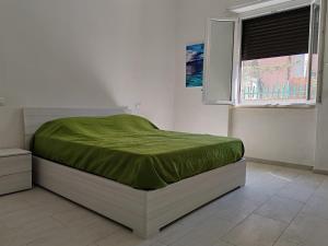 コッレサルヴェッティにあるVillettina con Bagni esclusiviの緑の毛布が掛けられたベッドのある寝室