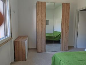 コッレサルヴェッティにあるVillettina con Bagni esclusiviのガラスのドアとベッドと鏡のある寝室