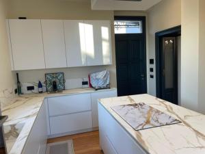 a kitchen with white cabinets and a marble counter top at VillaSu Event Experience in Missaglia +19 photos