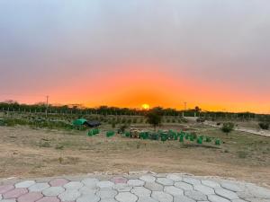 a farm with a sunset in the background at Dhan Valley Guest House in Bhaun