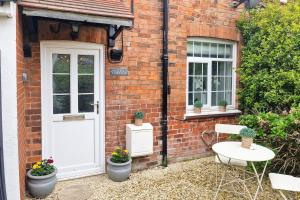 a brick house with a white door and two windows at Howells Cottage in Monmouth