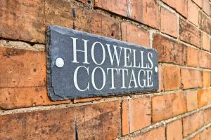 a sign on the side of a brick wall at Howells Cottage in Monmouth