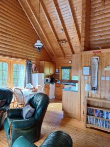 a kitchen and living room with leather furniture in a log cabin at Springburncabins in Elgin