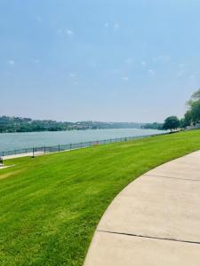 un marciapiede accanto a un campo d'erba accanto a uno specchio d'acqua di Marble Flatz a Marble Falls Altre 27 foto