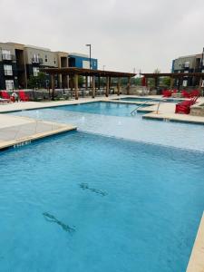 una grande piscina di acqua blu di fronte agli edifici di Marble Flatz a Marble Falls
