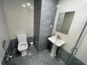 a bathroom with a toilet and a sink and a mirror at Caspian Mirvari 2 in Sumqayıt +7 photos