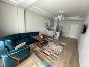 a living room with a blue couch and a table at Caspian Mirvari 2 in Sumqayıt