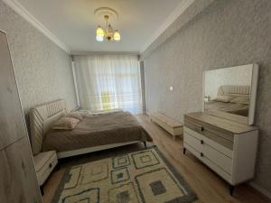 a bedroom with a bed and a mirror and a dresser at Caspian Mirvari 2 in Sumqayıt