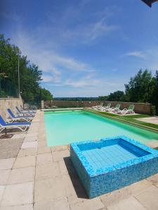 a swimming pool with lounge chairs around it at Lacoume Saint Jacques in Auch
