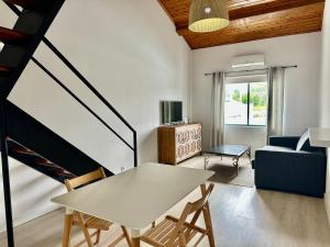 a living room with a table and a couch at AZORES PEDRA APARTMENTS - T0 e T1 in Ponta Delgada