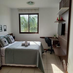 a bedroom with a bed and a desk and a window at Apt 2 Suítes no Life Resort com Vista parcial para o Lago e lazer completo in Brasilia