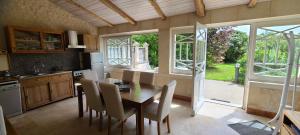 a kitchen with a wooden table and chairs in a kitchen at Le Domaine des Doucins & Spa, Gîte 4 étoiles, 10 minutes de Jonzac piscine et spa in Fontaines-dʼOzillac