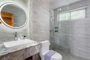 Un baño con inodoro, lavabo y espejo. en Reve Samui Luxe Seafront Residence with Panoramic Views, en Ban Bang Po 24 fotos más