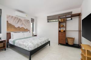 Un dormitorio con una cama y una estantería. en Reve Samui Luxe Seafront Residence with Panoramic Views, en Ban Bang Po