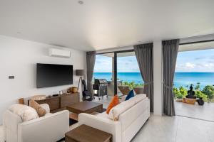 Una sala de estar con muebles blancos y vista al mar. en Reve Samui Luxe Seafront Residence with Panoramic Views, en Ban Bang Po