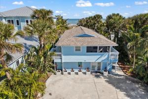 una vista aérea de una casa azul con palmeras en 111 S Atlantic Ave, en Cocoa Beach