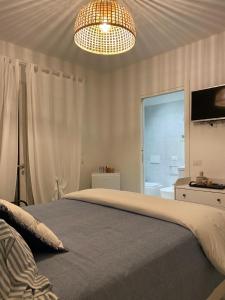 a bedroom with a large bed and a chandelier at Casa Vacanza La Molaretta di San Teodoro in San Teodoro