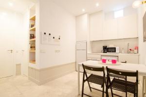 kuchnia z białymi szafkami, stołem i krzesłami w obiekcie Valverde Apartment w Madrycie +26 zdjęć