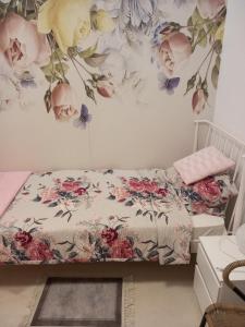 a bedroom with a bed with flowers on the wall at Smestaj Peric in Veliko Gradište