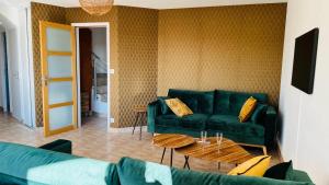 salon z zieloną kanapą i stołem w obiekcie VILLA TY EDEN - standing- dans JARDIN EXOTIQUE privé, PLAGE à 200m w mieście Clohars-Carnoët