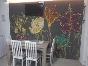 a dining room with a table and a flower mural at Smestaj Peric in Veliko Gradište