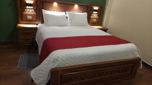 a bedroom with a large bed with a red and white blanket at Hotel Norte Potosí in Torotoro