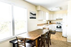 a kitchen with a wooden table and chairs at Watermen's Cabana 2C - 3-Bed, 2-Bath Apartment - Walk To BEACH Access & PET Friendly! in Waves
