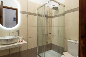 a bathroom with a glass shower and a sink at C'est La Vie Rooms and Suites in Laganas