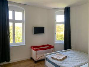 a bedroom with a bed and a tv on the wall at NEU! Vogtland Herberge Auerbach 3 Gäste und Baby in Auerbach