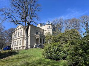 a large white house on top of a grassy hill at NEU! Vogtland Herberge Auerbach 3 Gäste und Baby in Auerbach