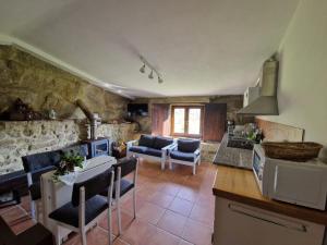 una cucina e un soggiorno con tavolo e sedie di Quinta Damigo a Seia